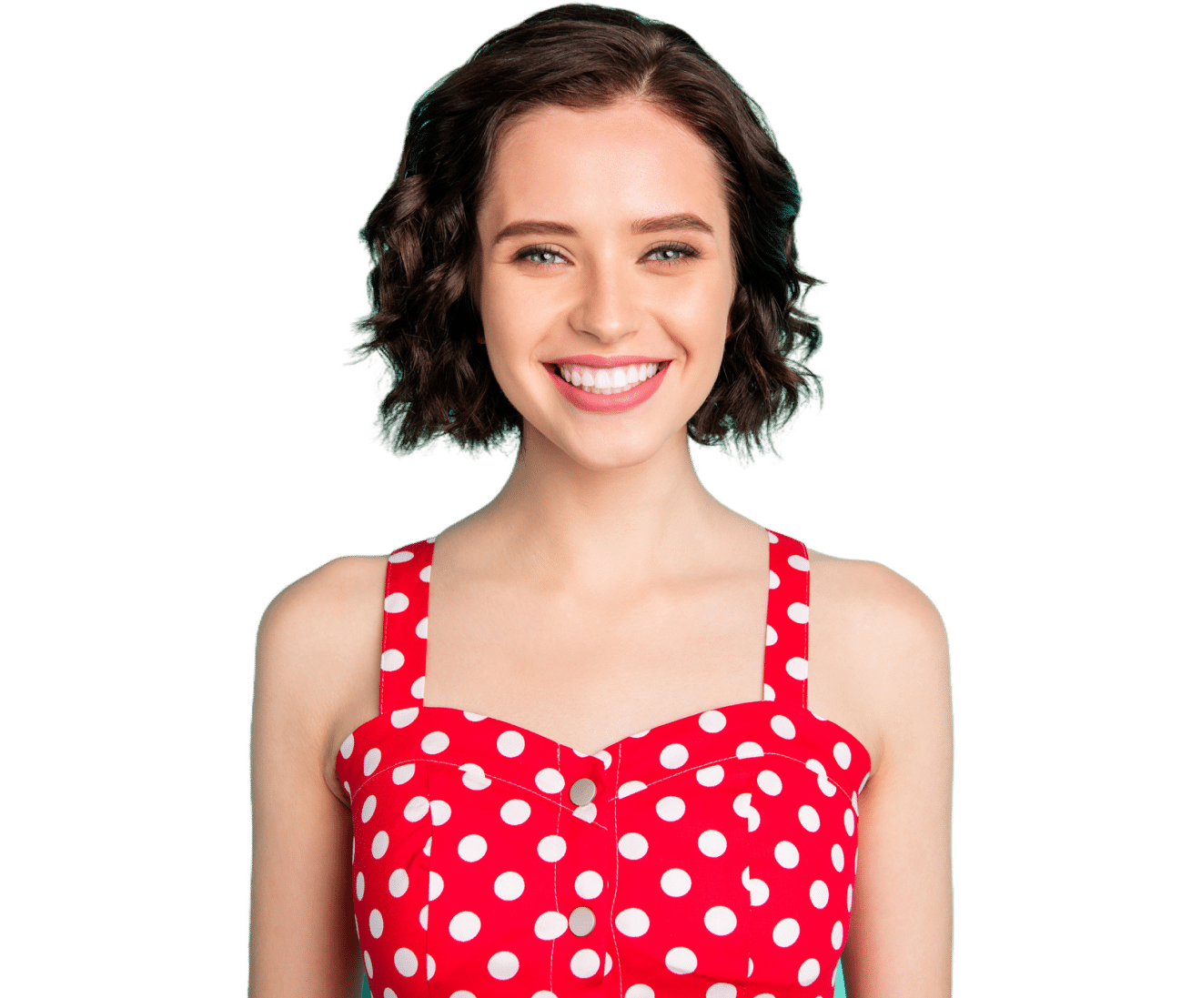 A person with short, curly hair is smiling, wearing a red polka dot dress. The background is plain white.